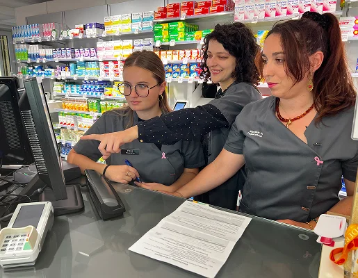 Trois pharmaciennes travaillent derrière le comptoir, l'une pointant un écran à Montgiscard en Haute-Garonne 31