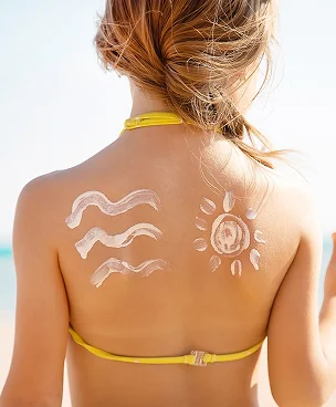 Dos d'enfant avec de la crème solaire formant des vagues et un soleil à la plage à Montgiscard en Haute-Garonne 31